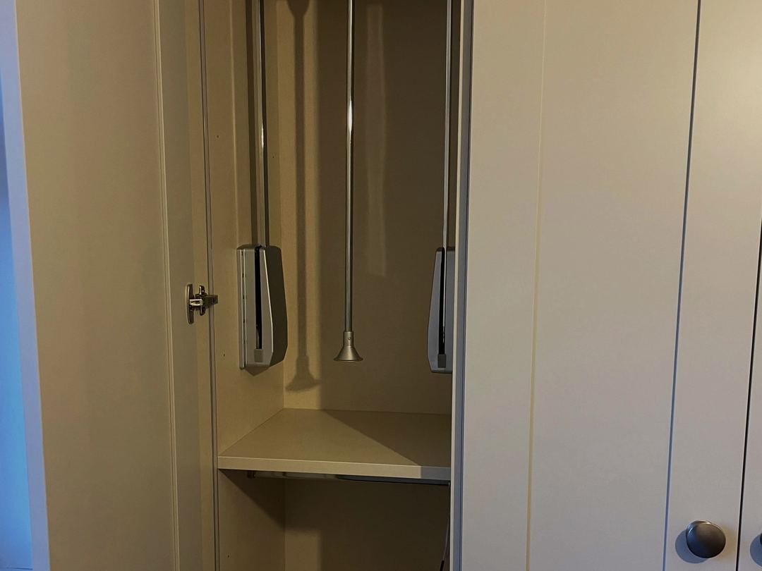 Ivory shaker wardrobes with a pull-down hanging rail