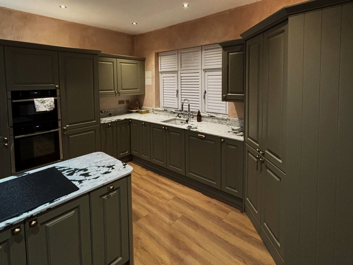Olive green shaker kitchen with brass handles and a quartz worktop