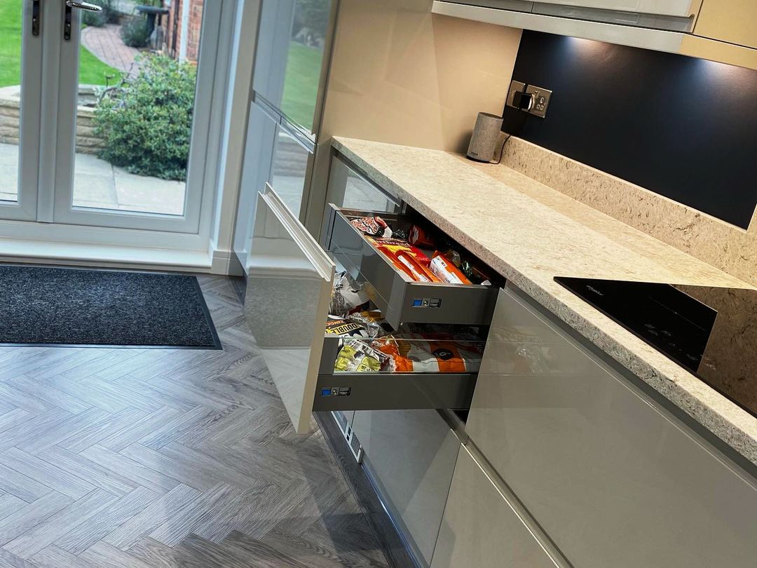 Open-plan gloss handleless kitchen with a herringbone floor
