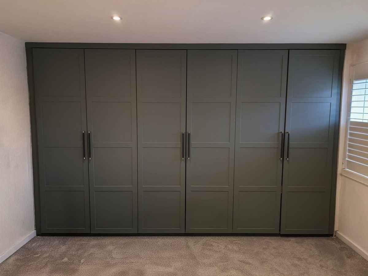 Fitted wardrobes with shaker-style doors across a full bedroom wall